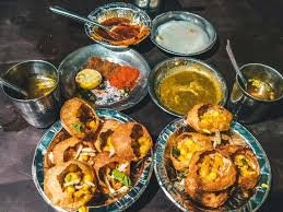 Crispy gol gappe filled with yogurt and chutneys arranged in a platter