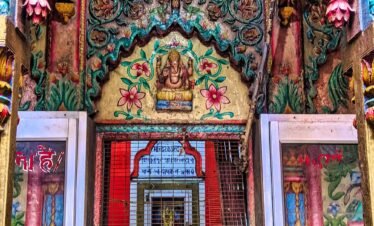 Colorful Hindu temple entrance with floral carvings and idol of Lord Ganesha in Varanasi