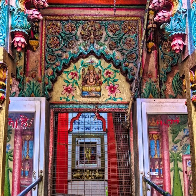 Colorful Hindu temple entrance with floral carvings and idol of Lord Ganesha in Varanasi