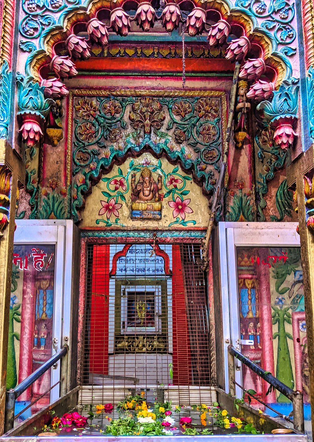 Colorful Hindu temple entrance with floral carvings and idol of Lord Ganesha in Varanasi